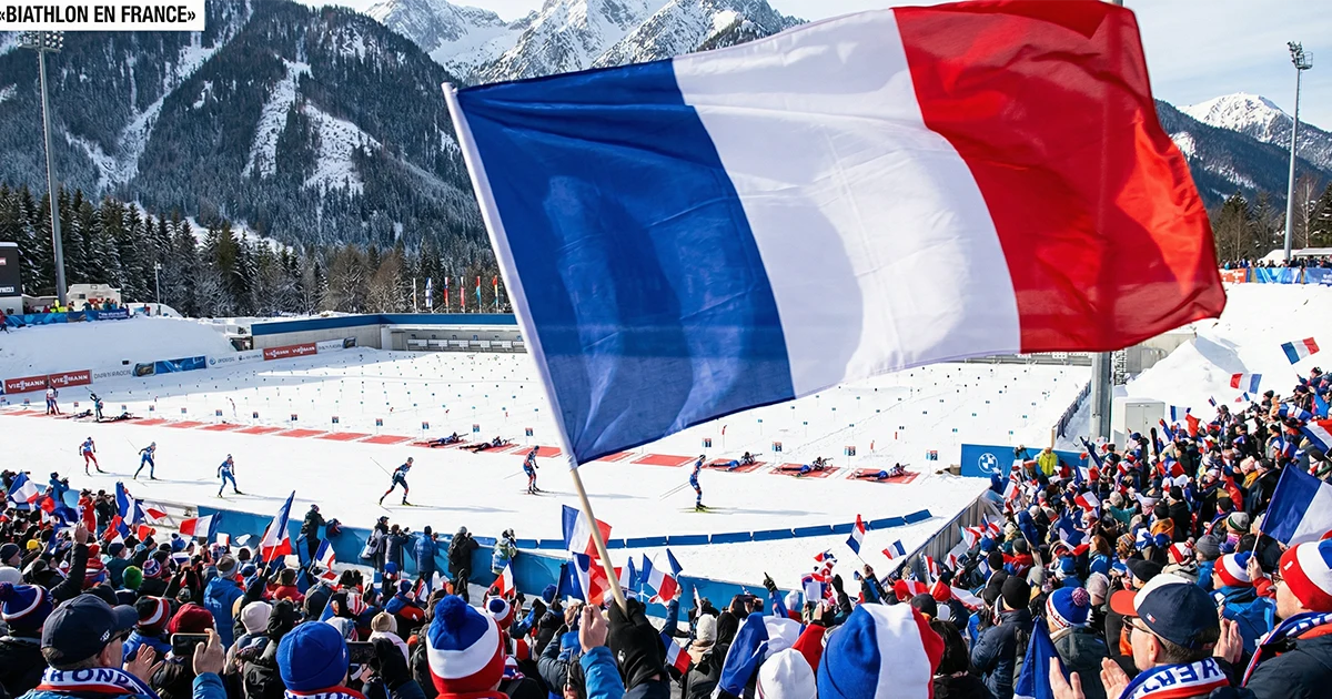 Drapeau français flottant sur un stade de biathlon enneigé avec tribunes et supporters français