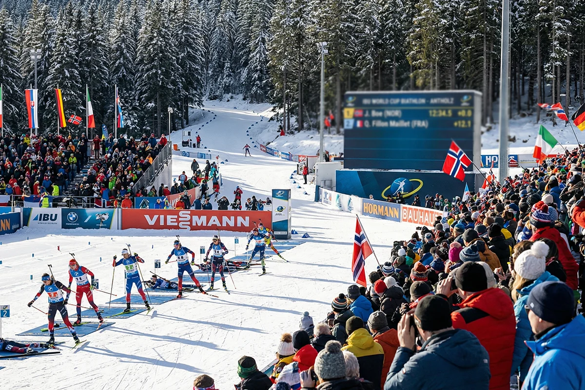 Vue d'ensemble d'un stade de biathlon avec les spectateurs suivant la course en direct et le tableau d'affichage des résultats